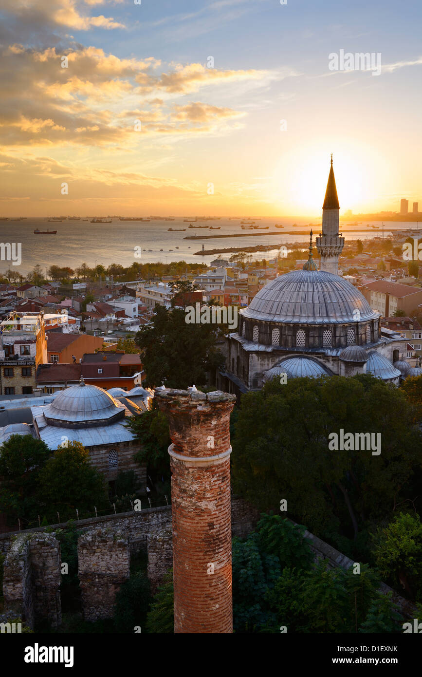 Setting sun behind the Sokollu Mehmet Pasha mosque minaret and historic Dervish ruins on the Marmara Sea Istanbul Turkey Stock Photo