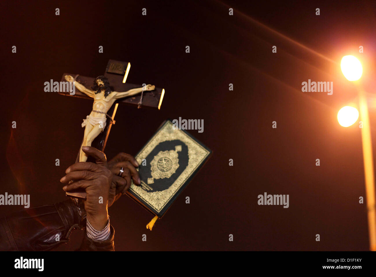 Dec. 18, 2012 - Cairo, Cairo, Egypt - A man holds a copy of the Koran and a cross as she shouts slogans during a demonstration against Egypt's President Mohamed Mursi in front of the presidential palace in Cairo December 18, 2012. Opponents of Mursi staged protests in Cairo on Tuesday against an Islamist-backed draft constitution that has divided Egypt but looks set to be approved in the second half of a referendum this weekend (Credit Image: © Ashraf Amra/APA Images/ZUMAPRESS.com) Stock Photo