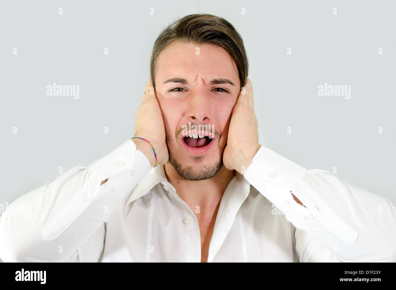 Irritated, frustrated, stressed guy covering his ears, too much noise