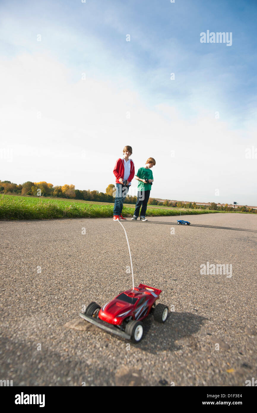Two boys playing with remote-controlled toy car Stock Photo