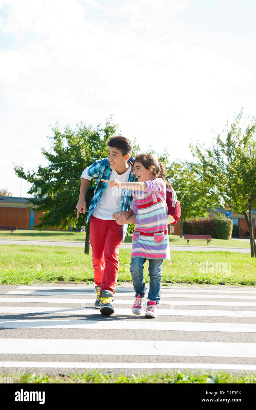 Girl and boy crossing street at crosswalk on a closed course Stock Photo