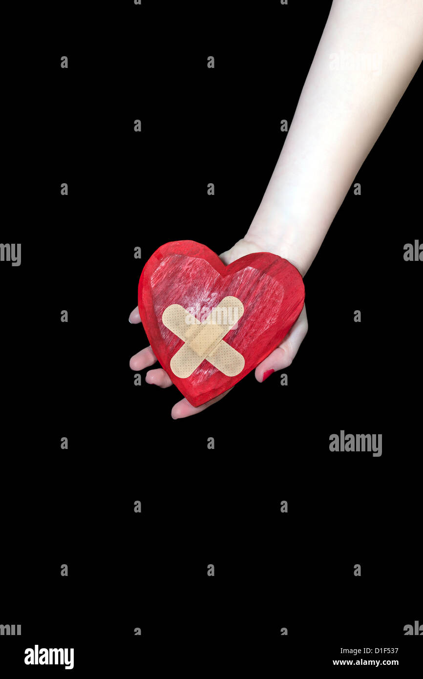 a female hand is holding a broken heart Stock Photo