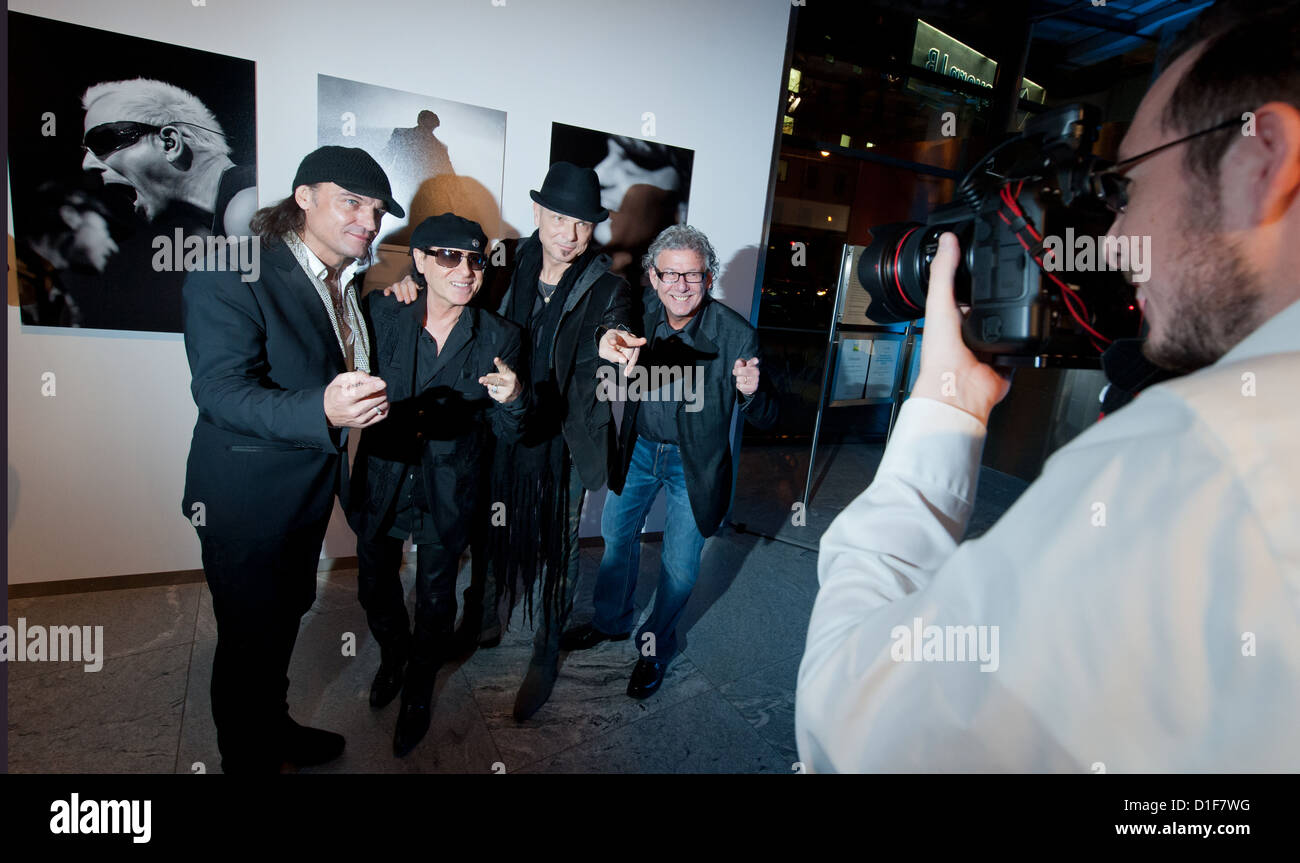 Member of rock band 'Scorpions' Matthias Jabs (L-R), Klaus Meine and Rudolf Schenker stand before the opening of a photo exhibition of photographs by Marc Theis (R) from Luxembourg in Munich, Germany, 18 December 2012. Last night, the final concert of the 'Final Sting World Tour 2012' took place in Munich. Photo: PETER KNEFFEL Stock Photo