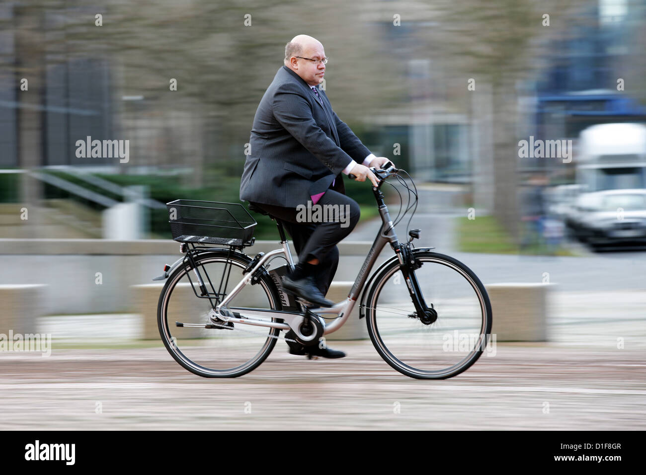 German environmental minister Peter Altmaier (CDU) rides an office e-bike at the ministry department in Bonn, Germany, 18 December 2012. Photo: ROLF VENNENBERD Stock Photo
