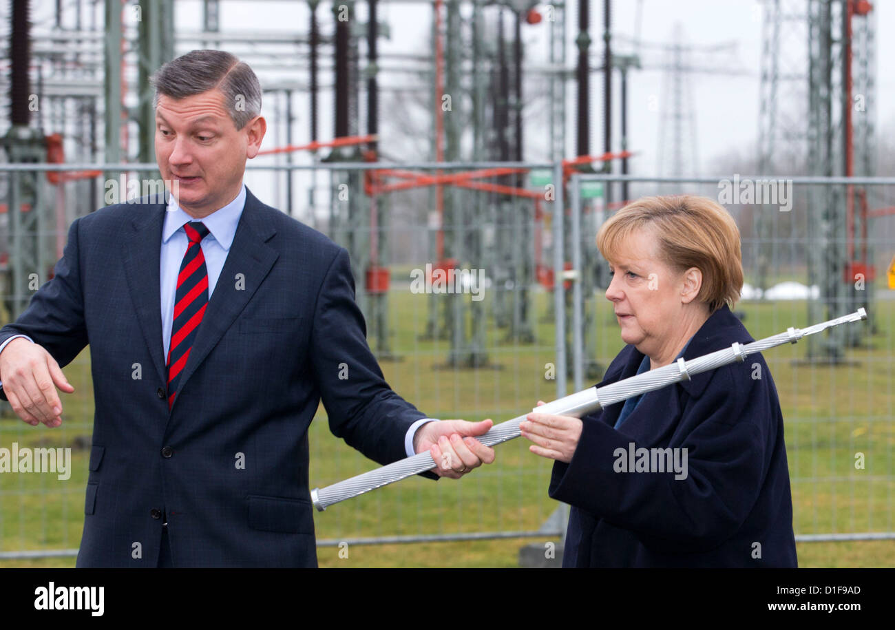 German chancellor Angela Merkel and the director of 50Hertz Boris Schucht (r) officially open the new East-West power circuit line in Schwerin, Germany, 18 December 2012. The 380-kw line is regarded as important part of the green energy turn. The current fast line transmits wind energy from North-East between Schwerin and the Kruemmel power plant in Geesthacht, Germany. Photo: JENS BUETTNER Stock Photo