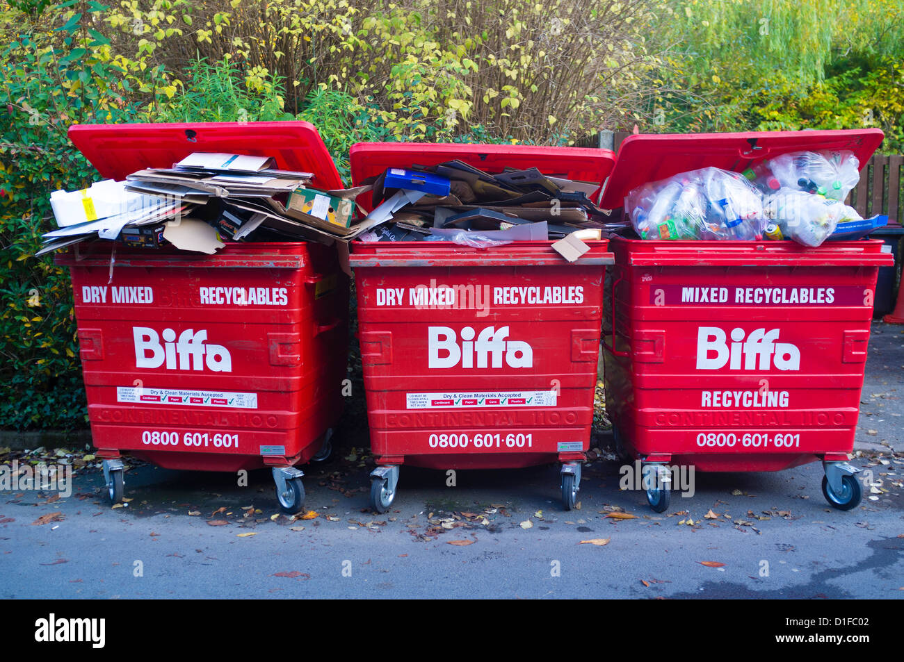 Three 3 red Biffa recycling skips full of mixed recyclable materials UK