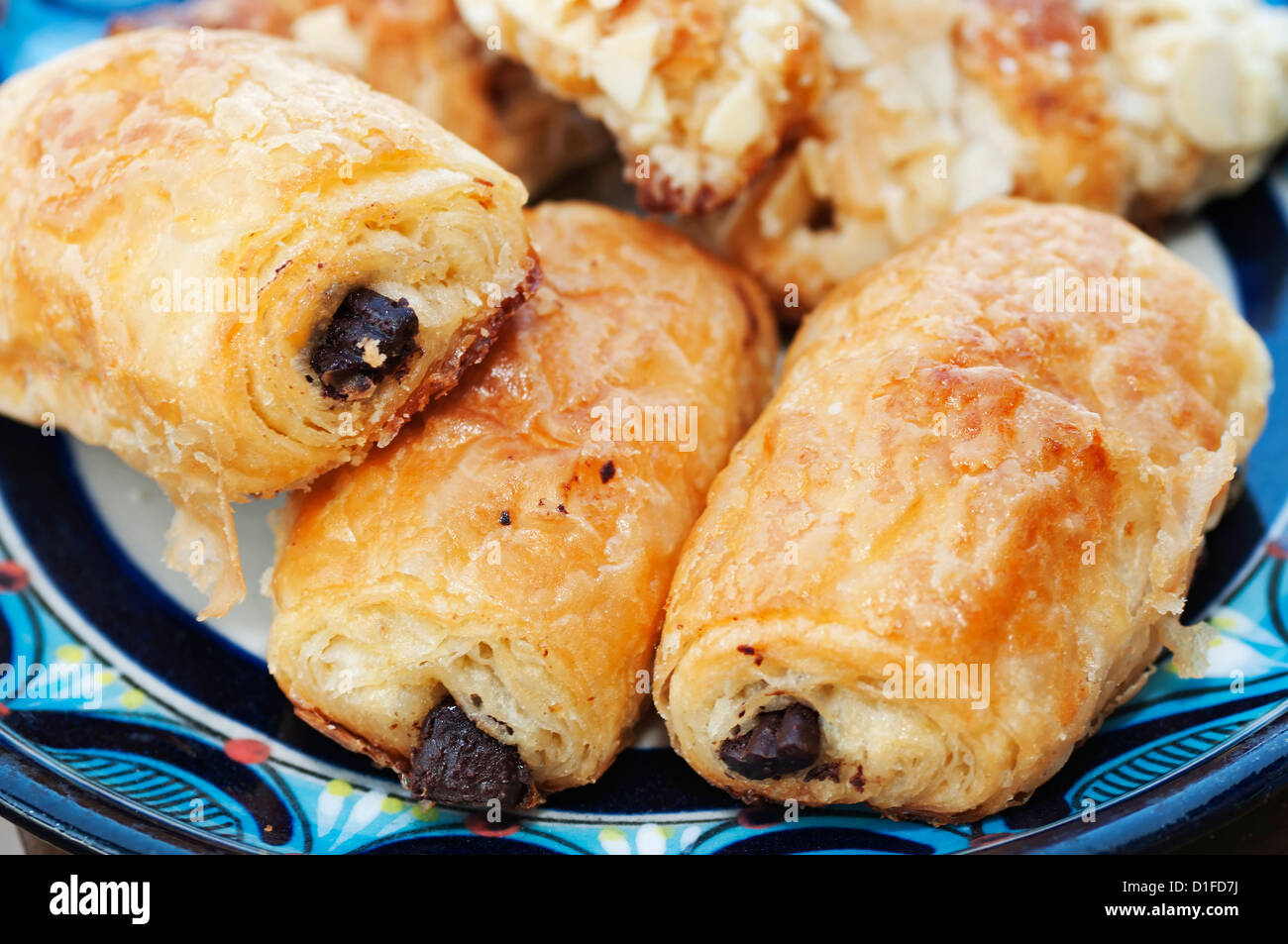 A plate filled with baked treats showcases miniature chocolate croissants. Stock Photo