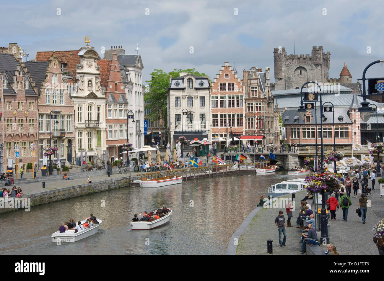 Scene along the Graslei bank, lined with Flemish gabled houses, Gravensteen Castle beyond, in the centre of Ghent, Belgium Stock Photo