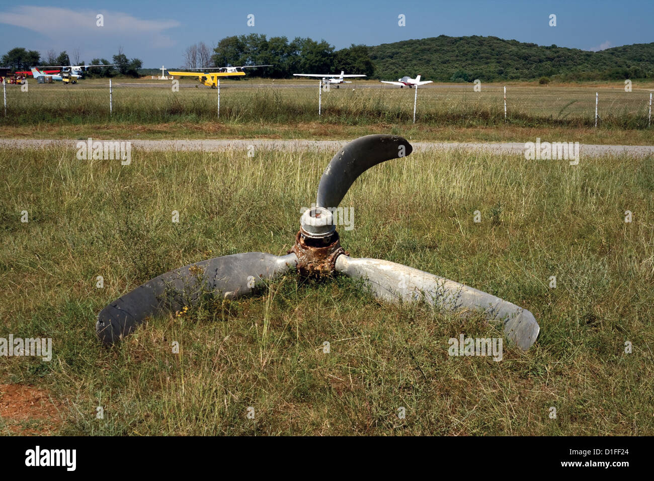 Damaged airplane propeller against small forest aerodrome Stock Photo