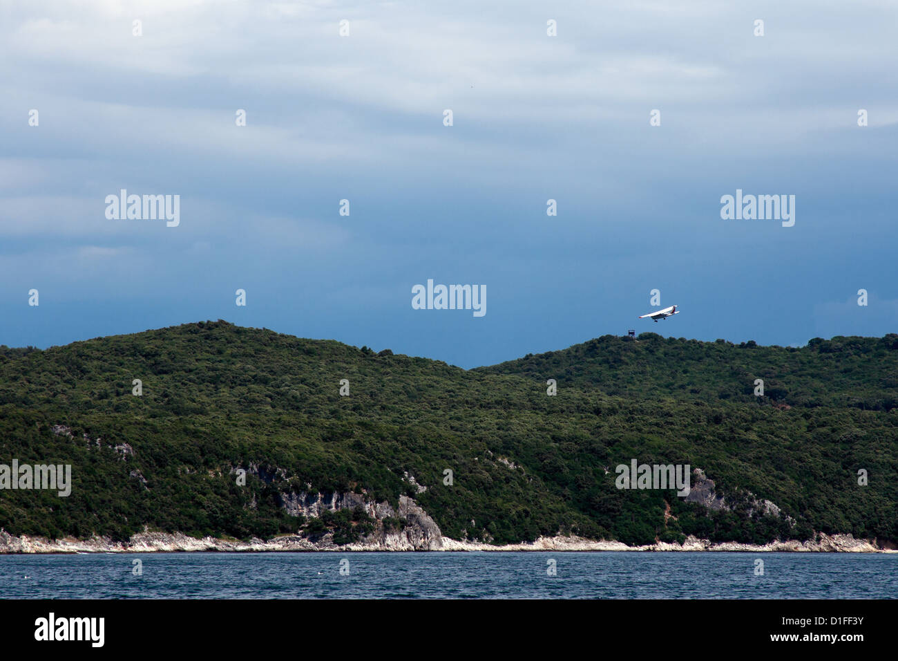 Small plane landing in forest mountain aerodrome. Limsky canal. Adriatic sea. Stock Photo