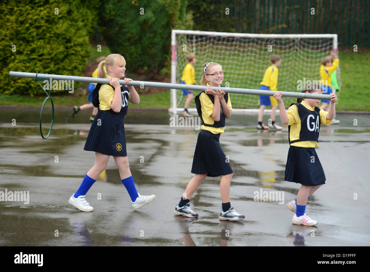 Schoolchildren carrying a netball goal at Our Lady & St. Werburgh's Catholic Primary School in Newcastle-under-Lyme, Staffordshi Stock Photo