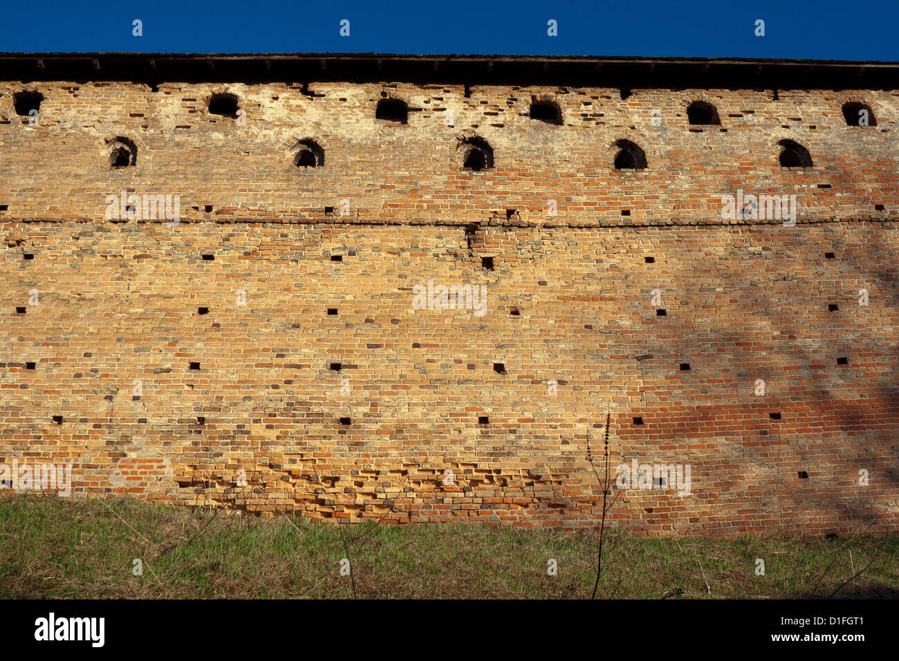 Brick wall with loopholes. Medieval castle. Stock Photo