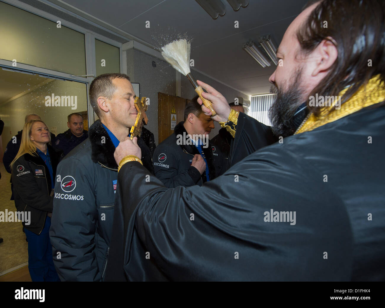 Expedition 34/35 Flight Engineer Tom Marshburn of NASA, left,  receives the traditional blessing from a Russian Orthodox priest at the Cosmonaut Hotel before launch to the International Space Station December 19, 2012 in Baikonur, Kazakhstan. Launch of a Soyuz rocket will send Marshburn, Roman Romanenko of Russia and Chris Hadfield of Canada on a five-month mission aboard the International Space Station. Stock Photo
