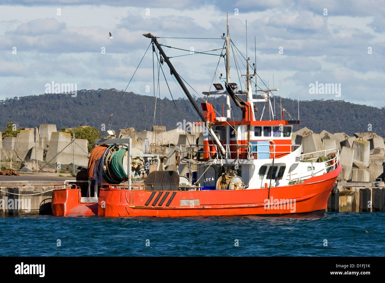 Red fishing boat / trawler moored at wharf at Eden, NSW Australia Stock Photo