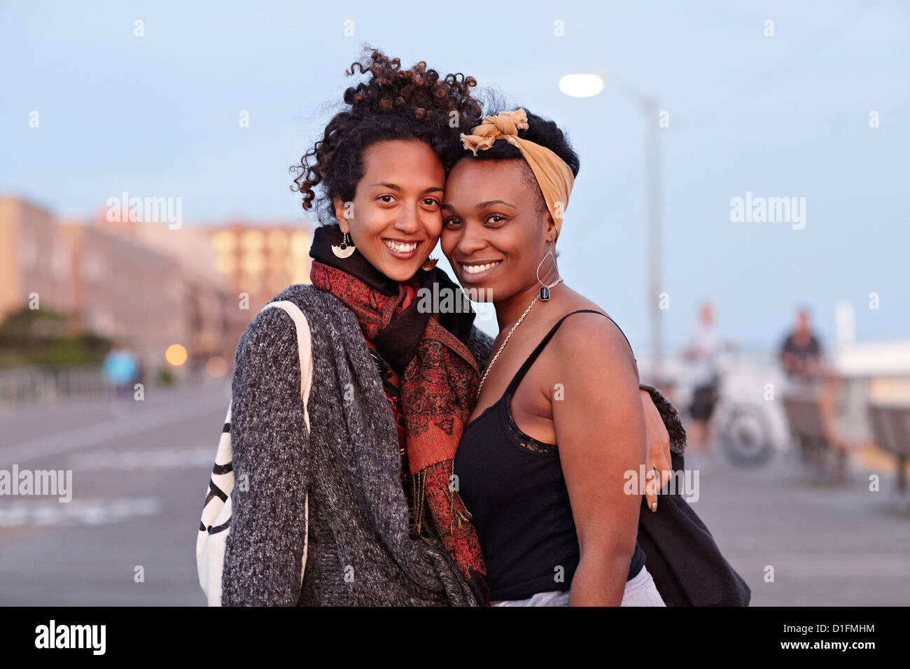 African American friends hugging on sidewalk Stock Photo