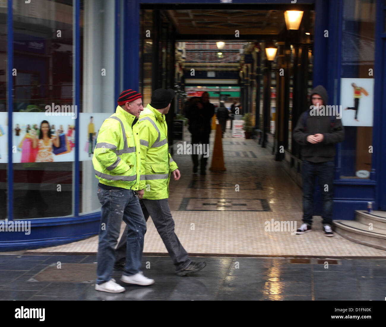 Two working men in high viz coats walking through the centre of Newport Gwent in South Wales, December 2012 Stock Photo