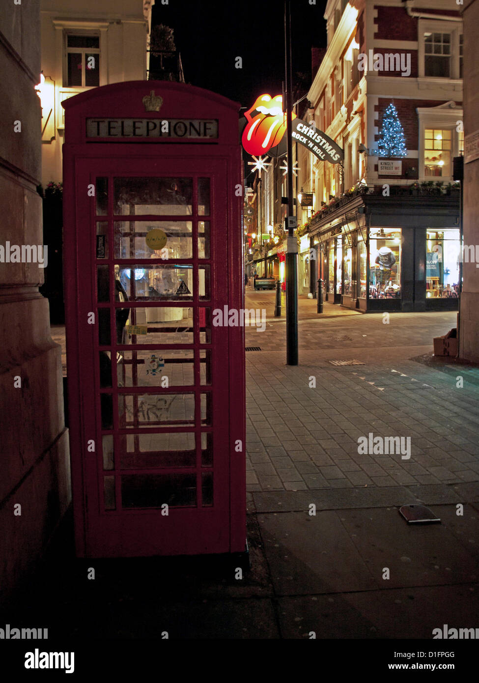 Telephone box on Carnaby Street, London, UK on 18th December 2012 showing the Carnaby arch dressed with The Rolling Stones' iconic tongue logo. Carnaby Street is world famous for its music heritage as well as its fashion heritage and this year’s Christmas installation is a collaboration with The Rolling Stones in celebration of their 50th Anniversary. Stock Photo