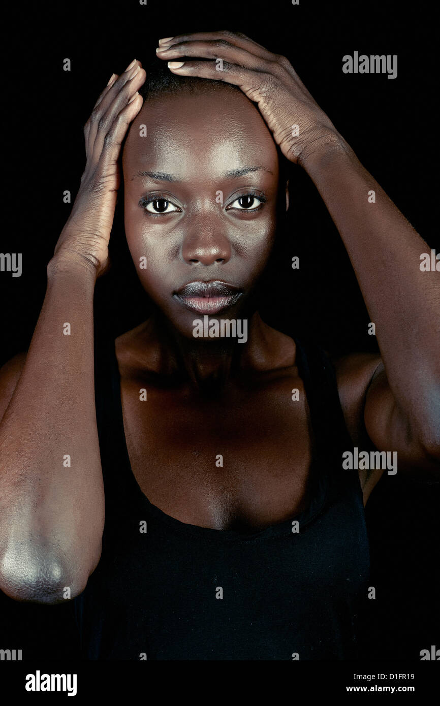 Serious African American woman with head in hands Stock Photo