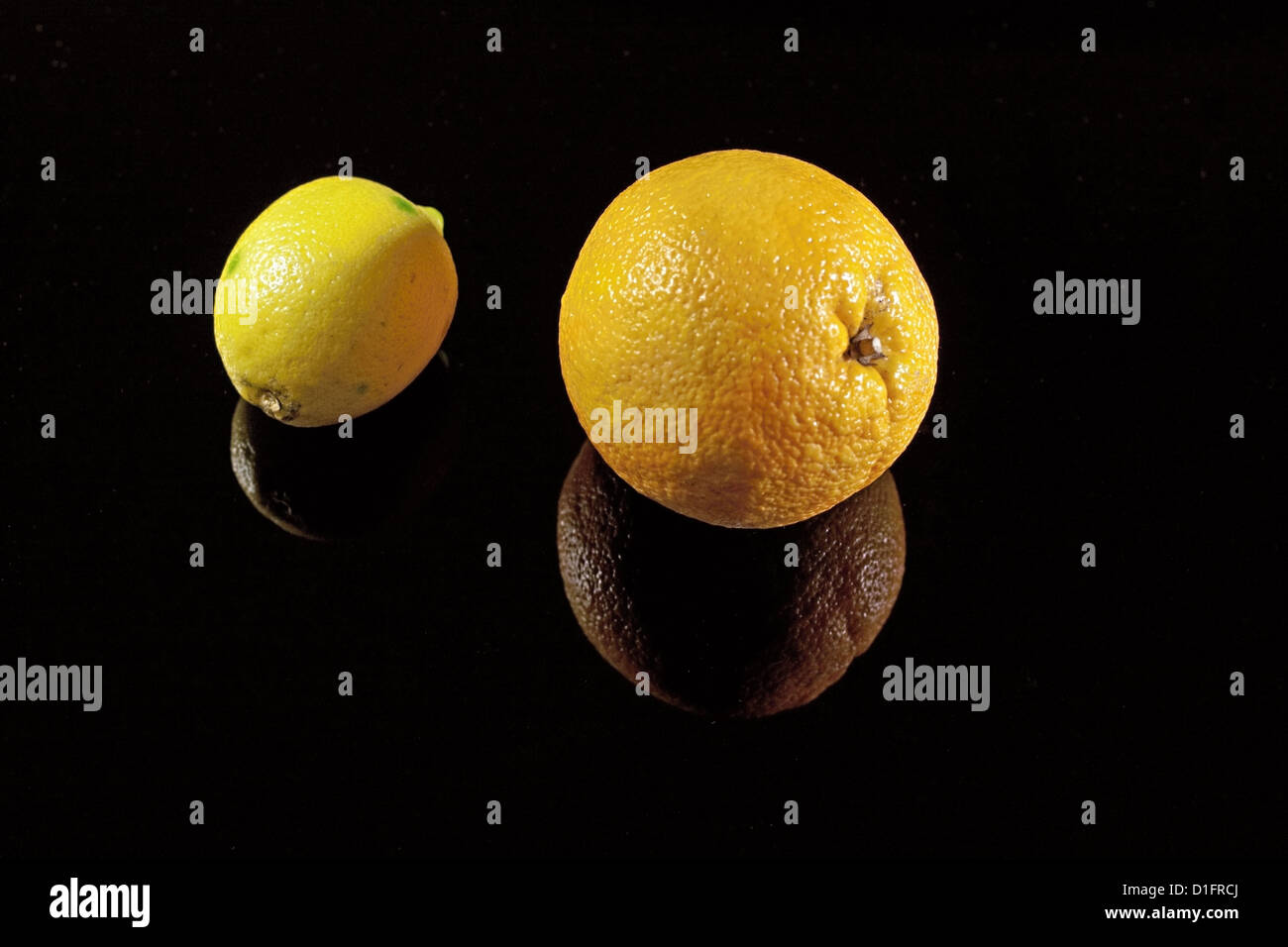 Orange and lemon on the black desk with shadows Stock Photo