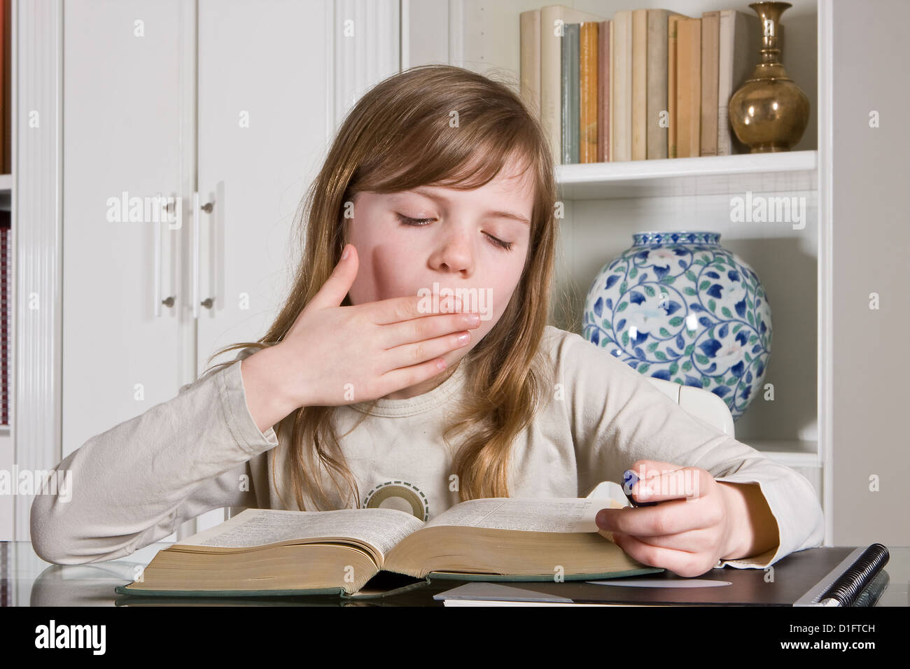 Young teenager girl studying a boring lesson Stock Photo