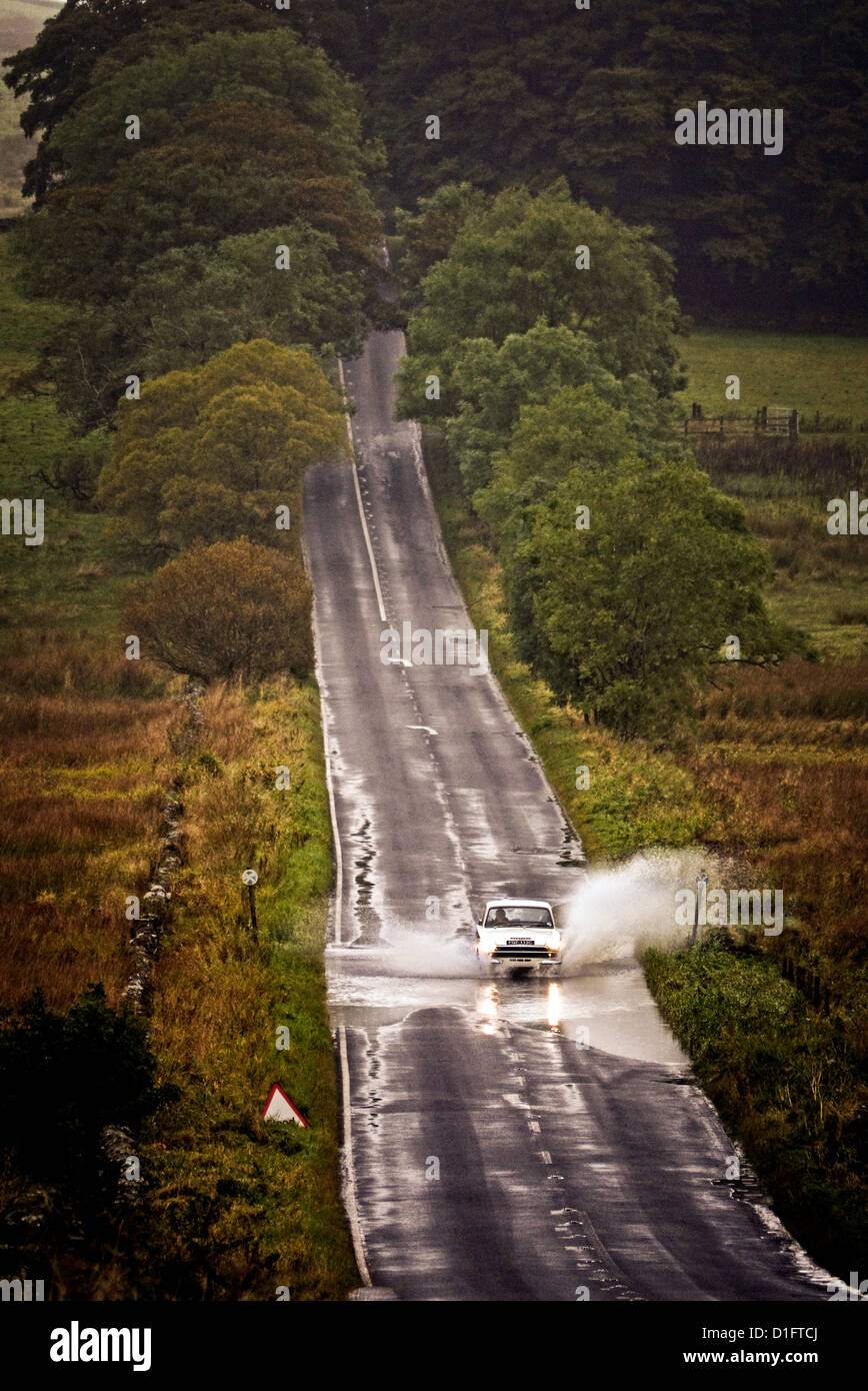 Ford Lotus Cortina MK1 driving through a flooded road in Northumberland UK Stock Photo