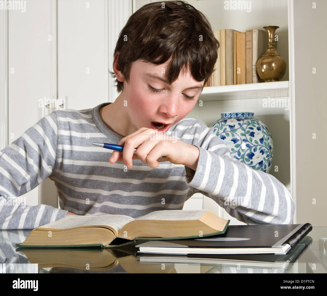 Young teenager boy studying a boring lesson Stock Photo