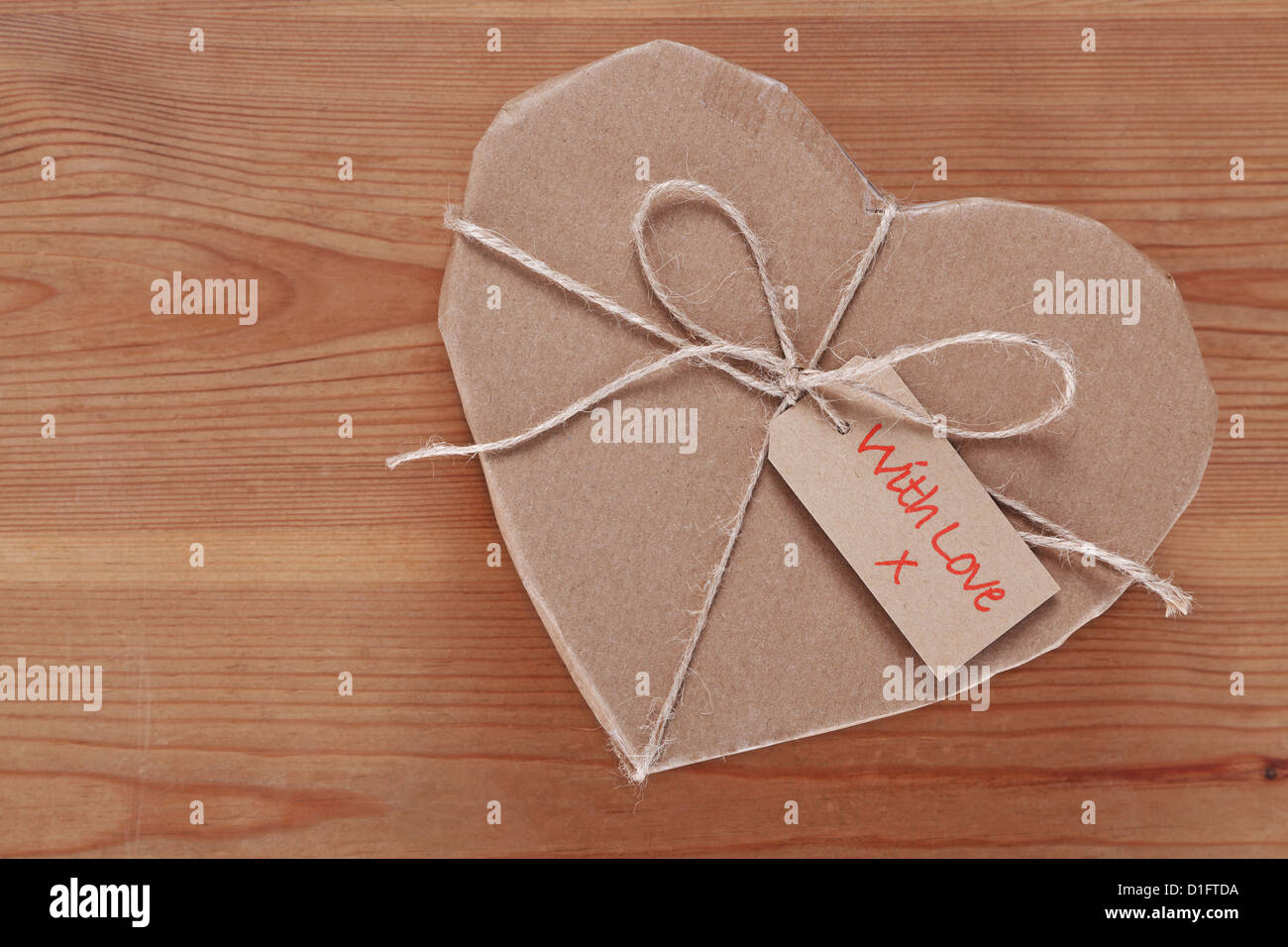 A heart shaped brown paper parcel with a label saying With Love. Stock Photo