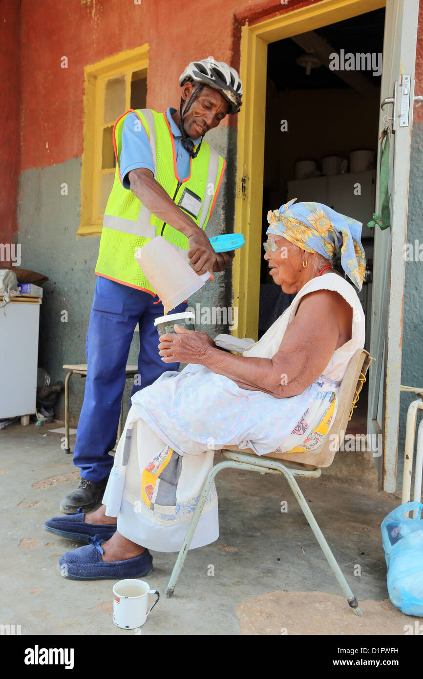 A volunteer of the Leoni´s Care Center NGO in Tsumeb/Namibia brings soup to the poor of a township Stock Photo