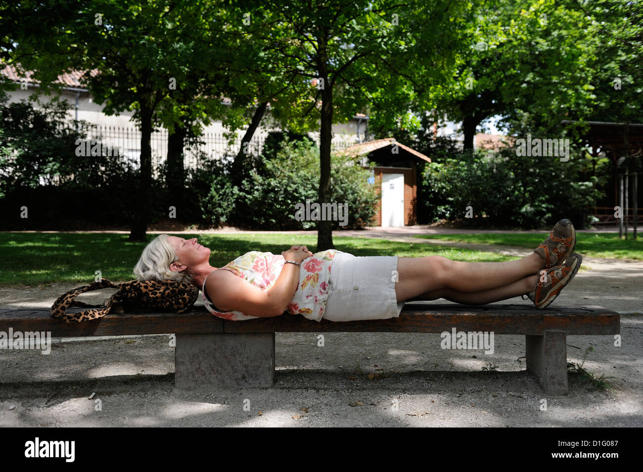 Stock photo of a woman lying on a park bench in the sun Stock Photo - Alamy