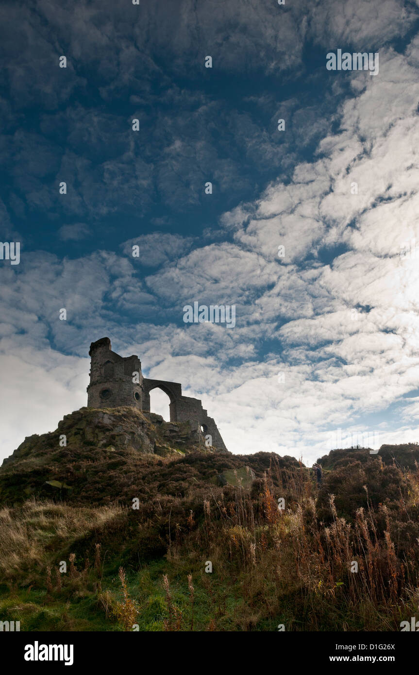 Mow Cop Castle, a folly on the Cheshire-Staffordshire border; from a low angle, semi-silhouetted on blue sky with white clouds. Stock Photo