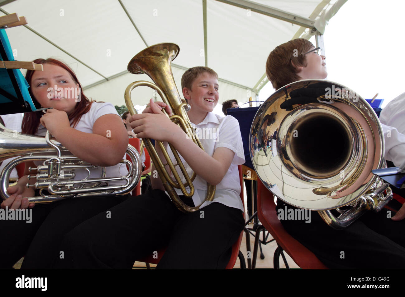 Three children members of Leiston Legion Brass Band, waiting their turn to play perform, Suffolk, UK Stock Photo
