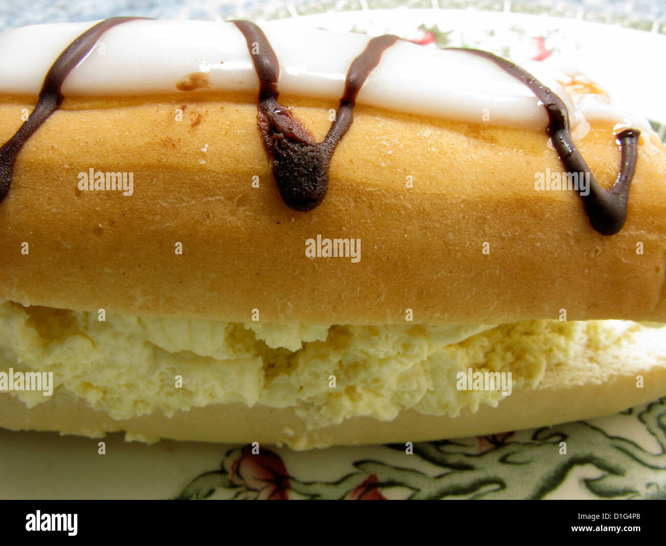 Iced cream bun on a plate as a teatime treat Stock Photo