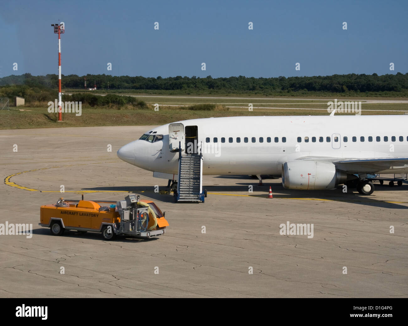 Plane parked at the airport with support car Stock Photo