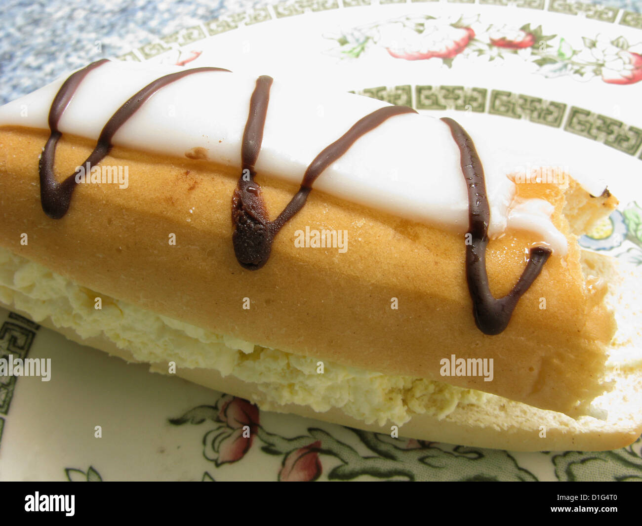 Iced cream bun on a plate as a teatime treat Stock Photo