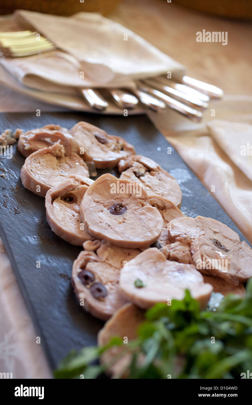 Rabbit roast with olives sliced for serving Stock Photo - Alamy