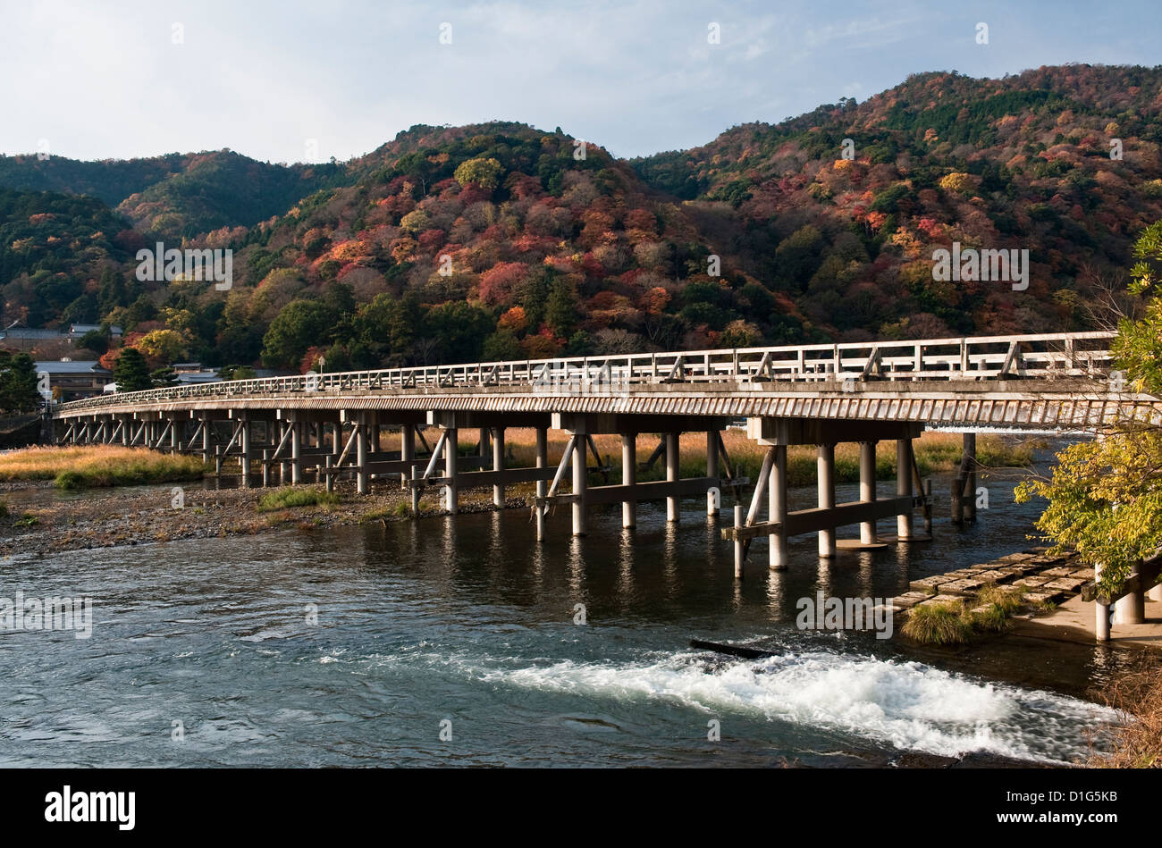 A view of the 'Moon Crossing Bridge' (Togetsukyo) on the Katsura river below Mt Arashiyama, in autumn - Arashiyama, Kyoto, Japan Stock Photo