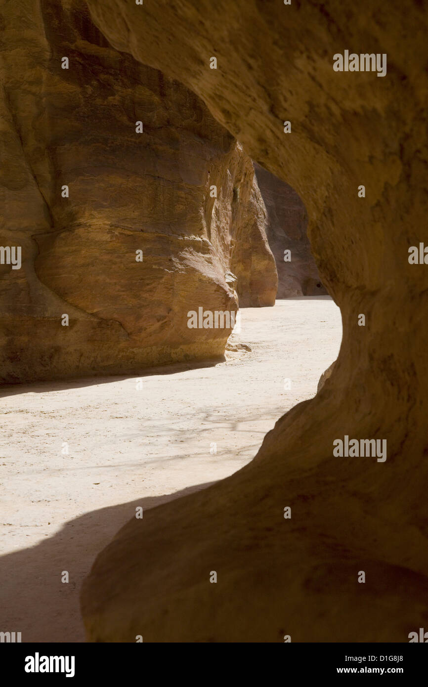 Light highlights the path through the Siq to the ancient city, Petra, Jordan. Stock Photo