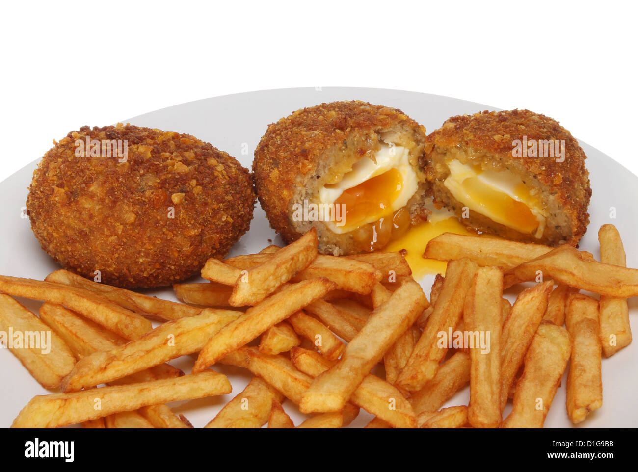 Runny Scotch eggs and chips on a plate Stock Photo