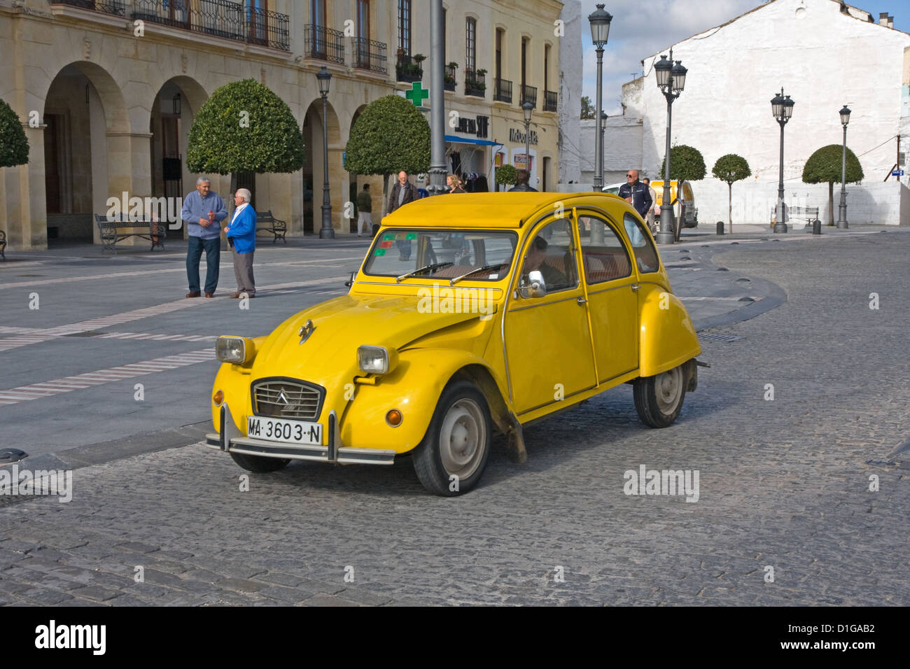 Yellow Citroen 2CV, with 2 horse heads mascots on bonnet, outside Paradores Hotel, Ronda, Spain Stock Photo