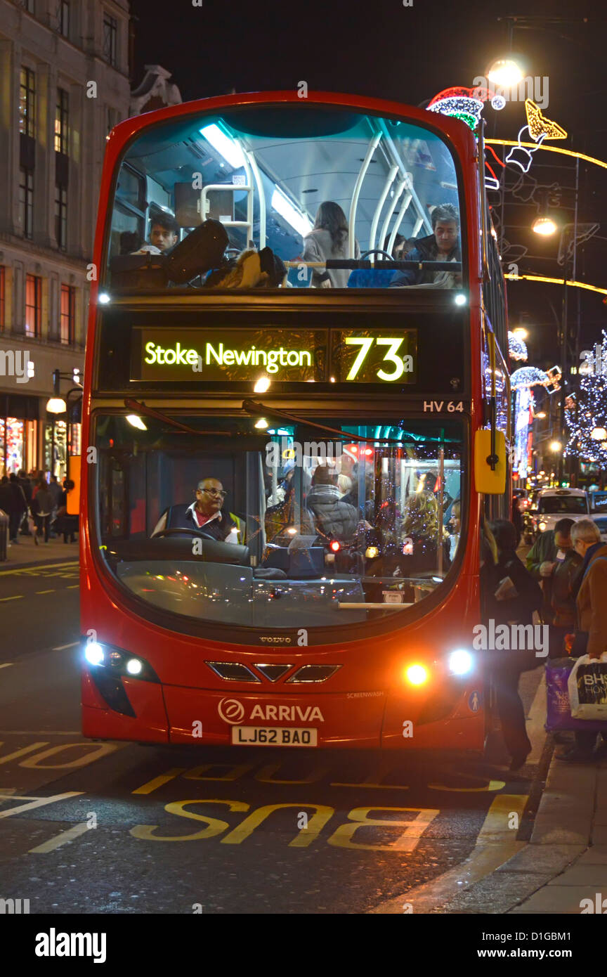 London double decker bus shoppers boarding at bus stop night Stock Photo
