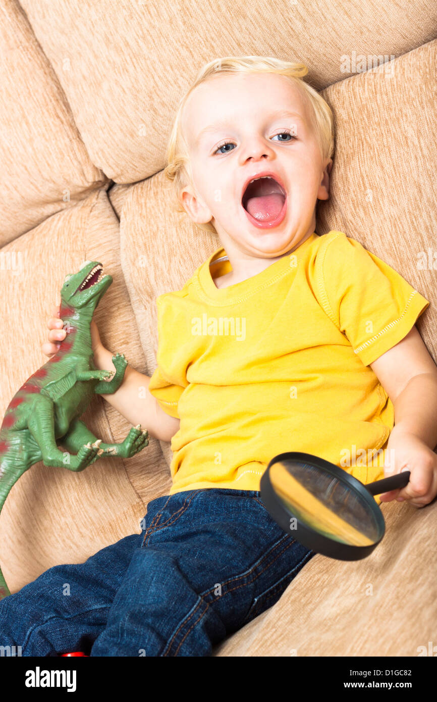 Close up of happy laughing child boy playing on sofa. Stock Photo