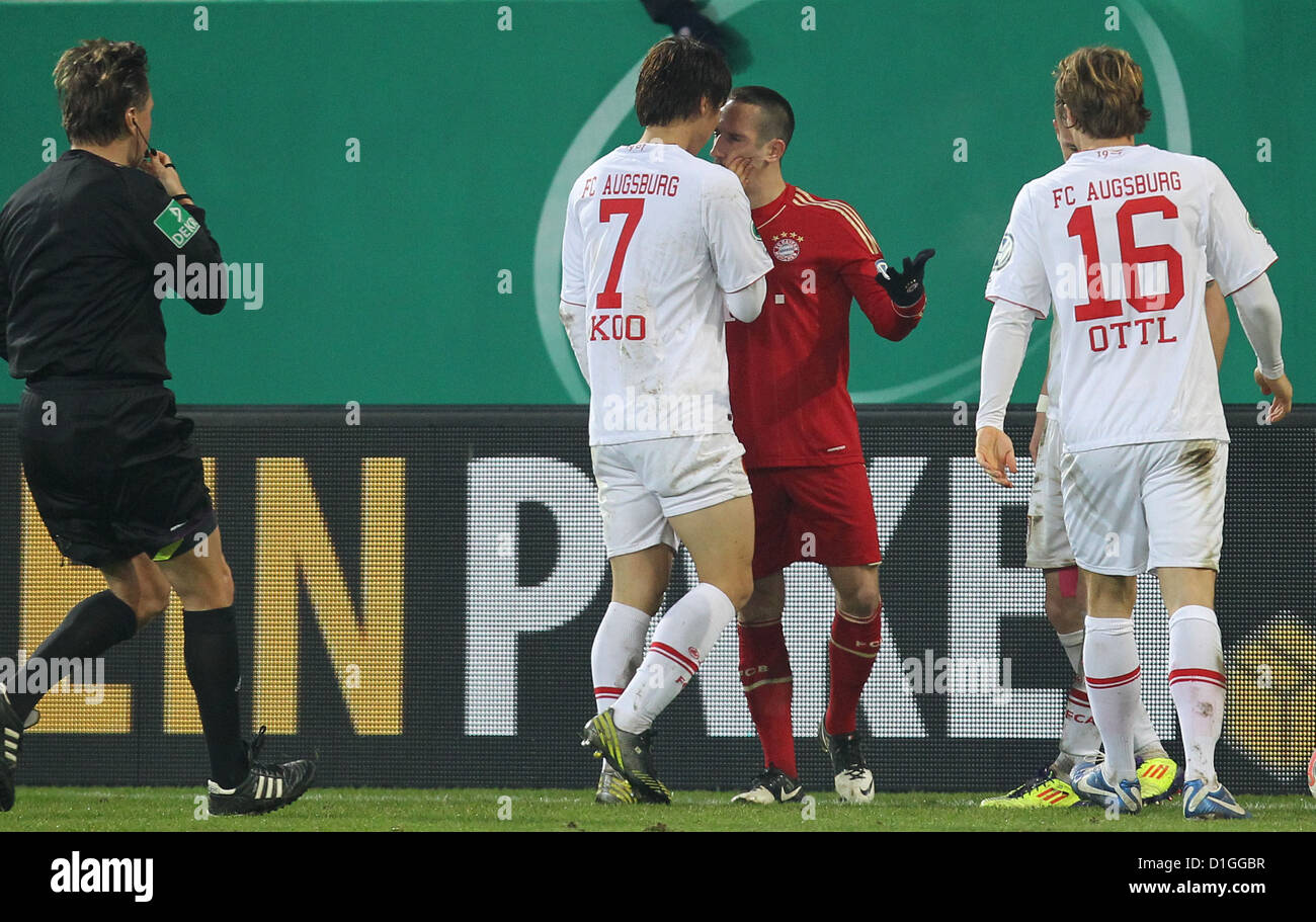 Augsburg's Ja-Cheol Koo (C-L) touches the face of Munich's Franck Ribery during the round of the last 16 DFB Cup match between FC Augsbirg and Bayern Munich at SGL Arena in Augsburg, Germany, 18 December 2012. Referee Thorsten Kinhoefer (L) and Augsburg's Andreas Ottl (R) look on. Photo: Karl-Josef Hildenbrand Stock Photo