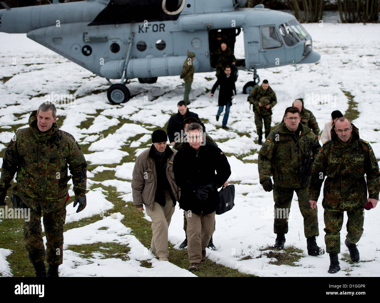Verteidigungsminister Thomas de Maiziere (M/CDU) steigt am 20.12.2012 in Zupce im Kosovo aus einem KFOR-Hubschrauber. De Maiziere besucht für einen Tag die deutschen KFOR-Soldaten im Kosovo. Foto: Axel Schmidt/dpa (zu dpa 0488 vom 20.12.2012) Stock Photo