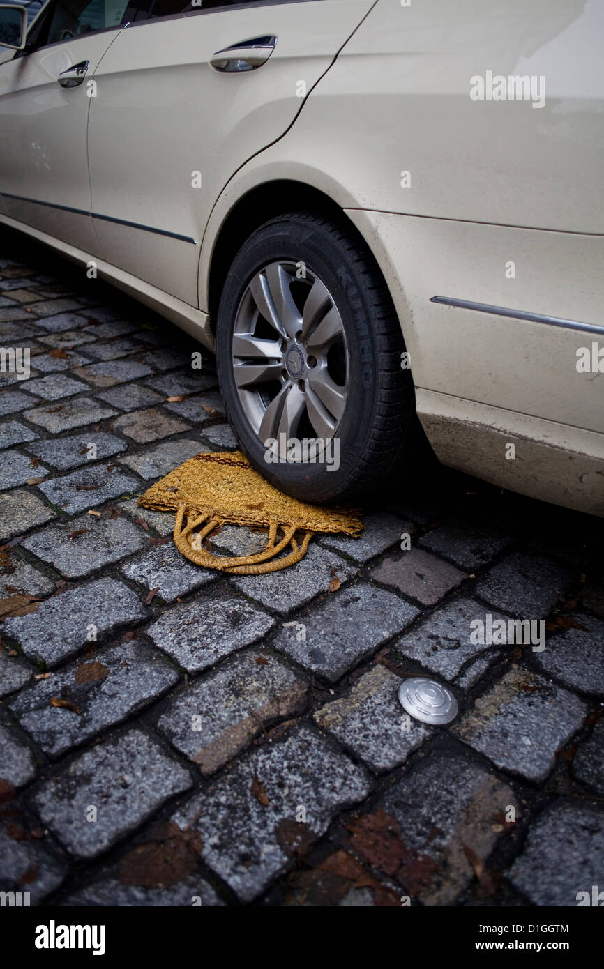 A bag is stuck under the wheel of a car in Berlin-Neukoelln, Germany, 19 December 2012. Photo: Inga Kjer Stock Photo
