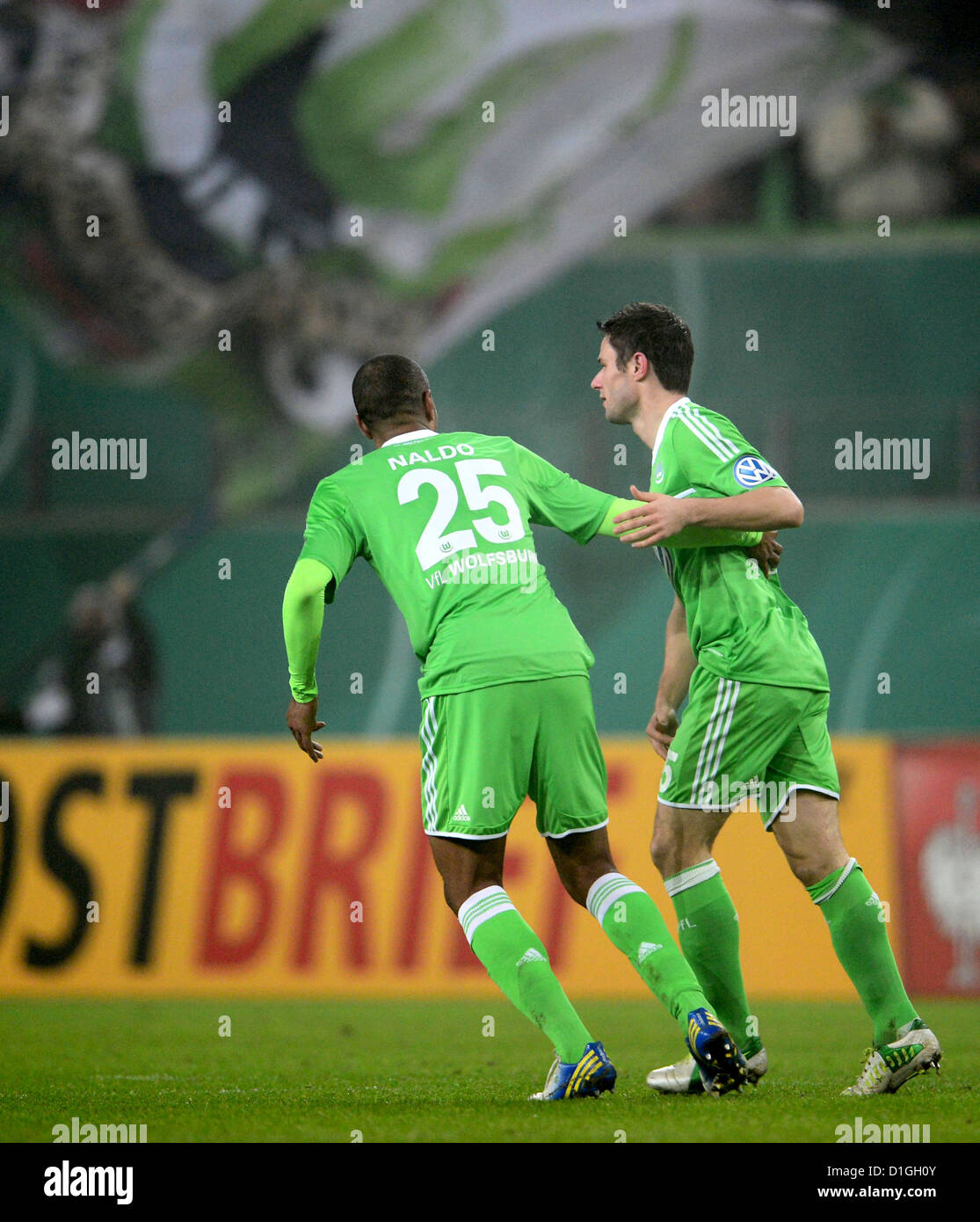 Wolfsburg's Christian Traesch cheers with his teammate Naldo (L) after scoring the 1-1 equaliter in the DFB Cup soccer match between VfL Wolfsburg and Bayer Leverkusen at the Volkswagen-Arena in Wolfsburg, Germany, 19 December 2012. Photo: Peter Steffen Stock Photo