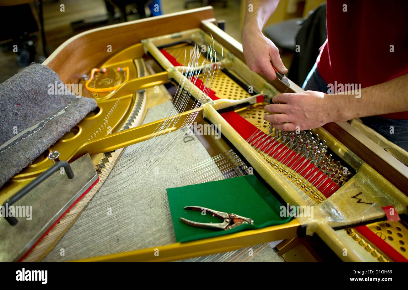 A craftsmn works on a grand piano at piano manufacturer Steinway in  Hamburg, Germany, 20 November 2012. German piano manufacturers had been  under pressure from competitors from the far east. After several