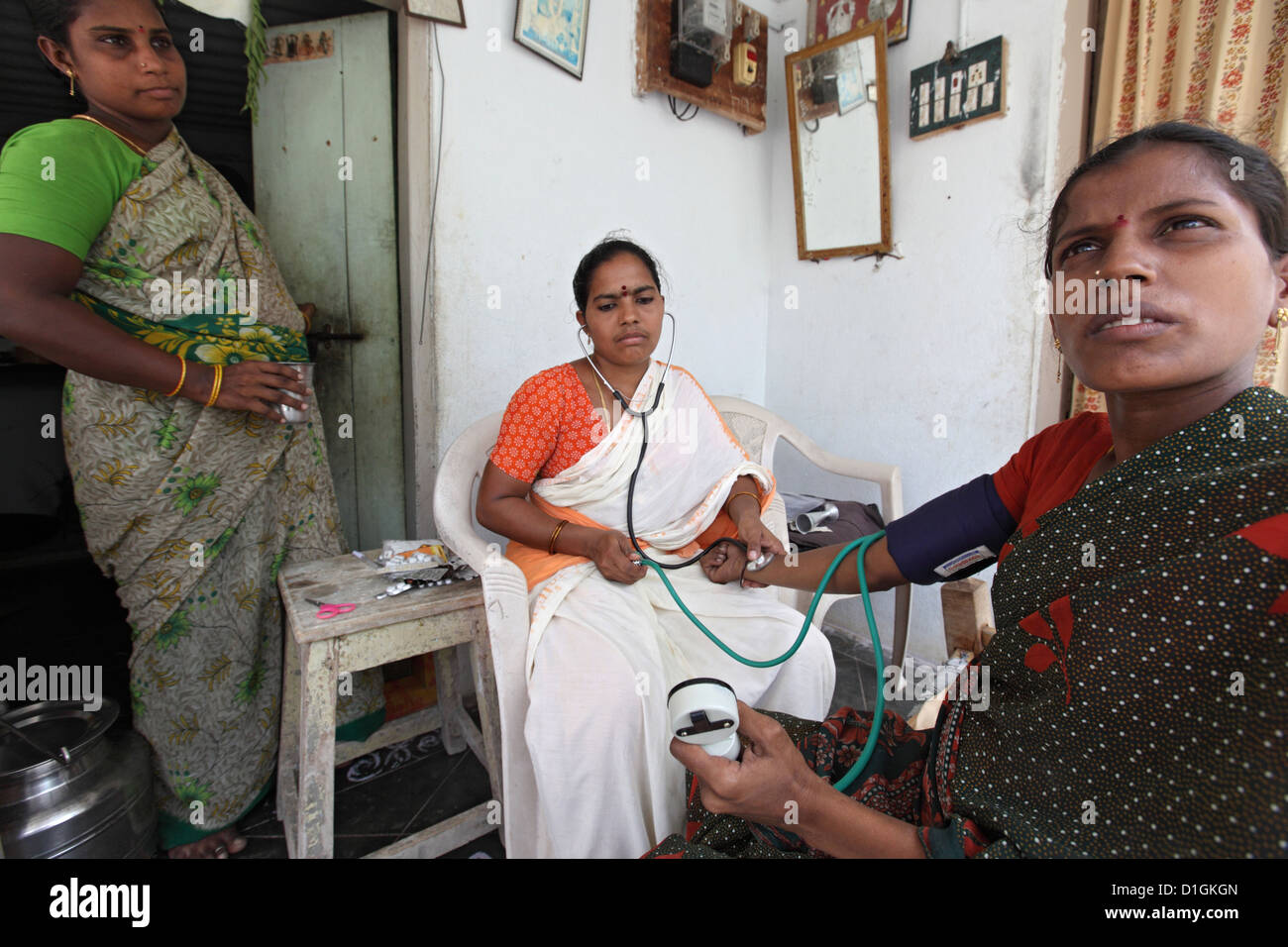RR Colony, India, a nurse examines a pregnant woman Stock Photo