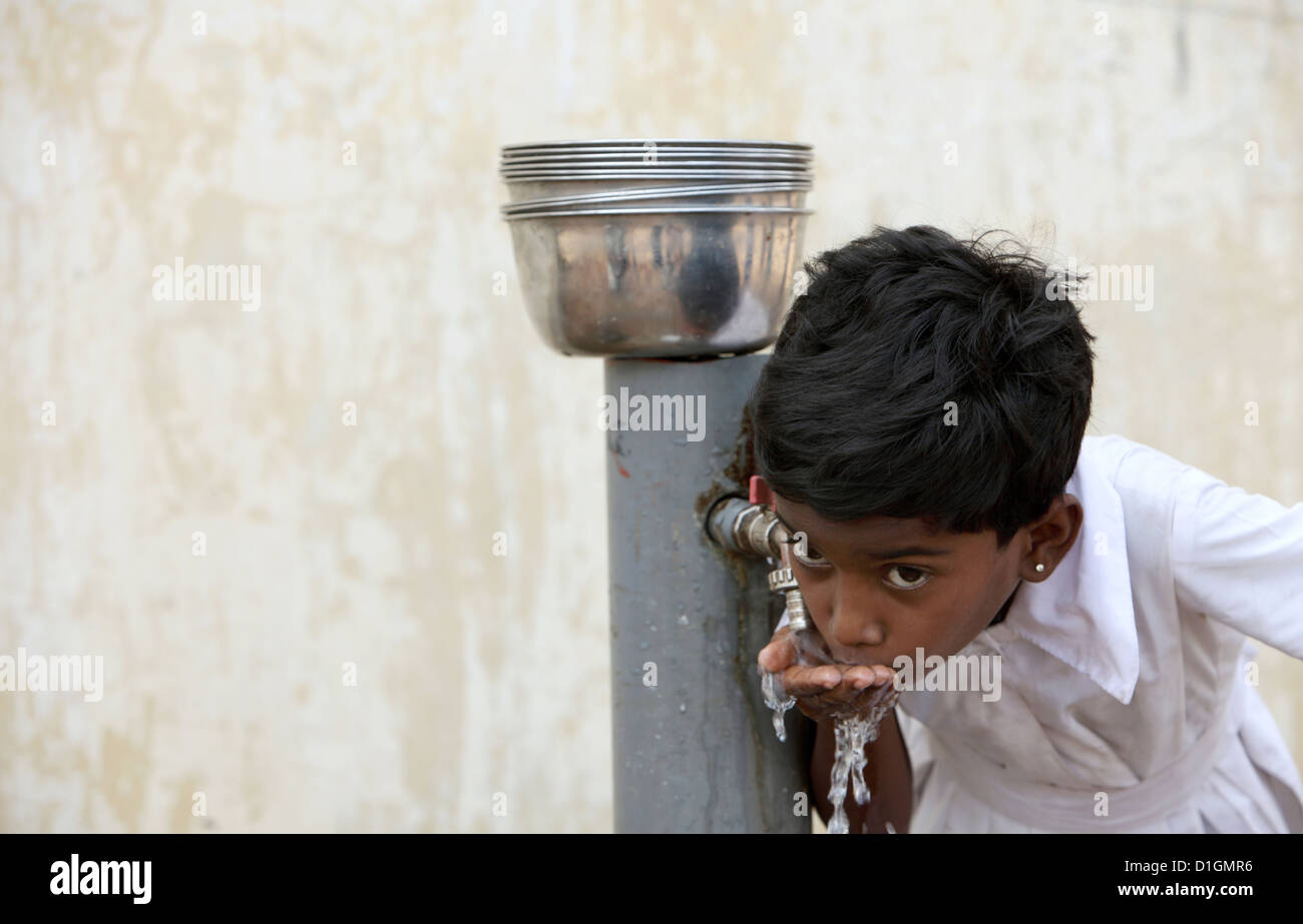 Navatkerny, Sri Lanka, a girl is drinking clean water from a water pump