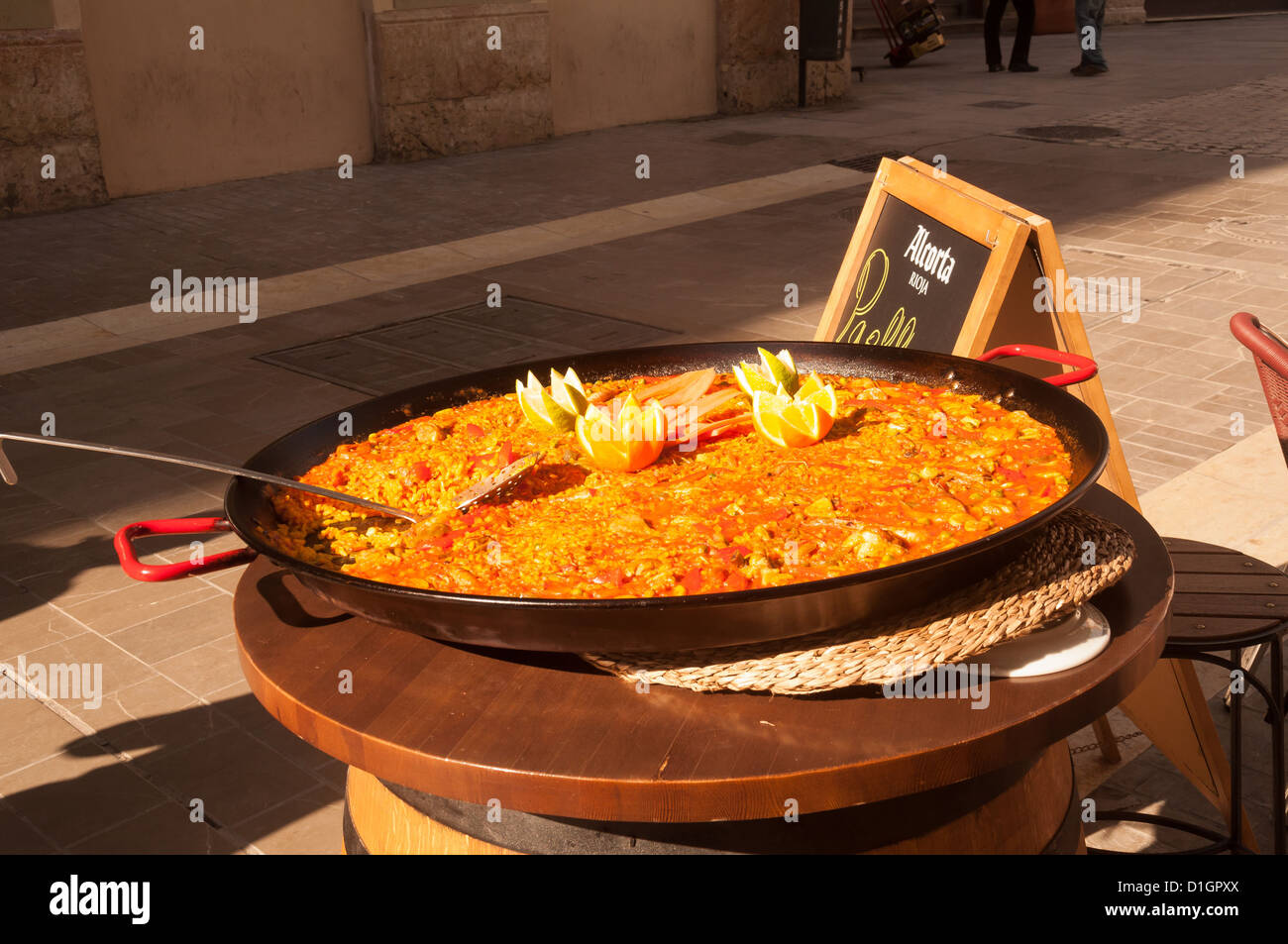 A traditional paella decorated with oranges and lemons Stock Photo