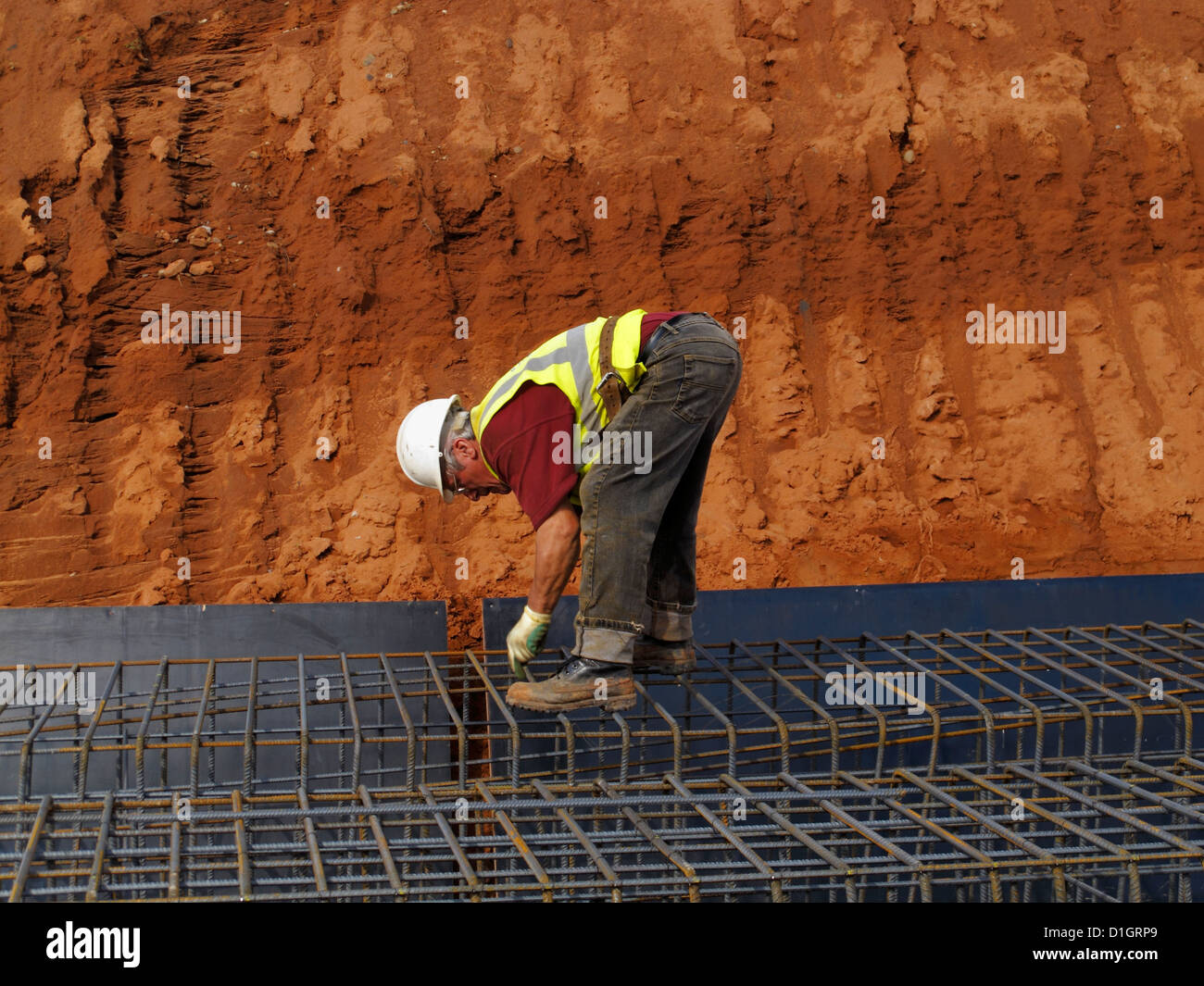 Steel fixer tying reinforcement bars in a bridge foundation base